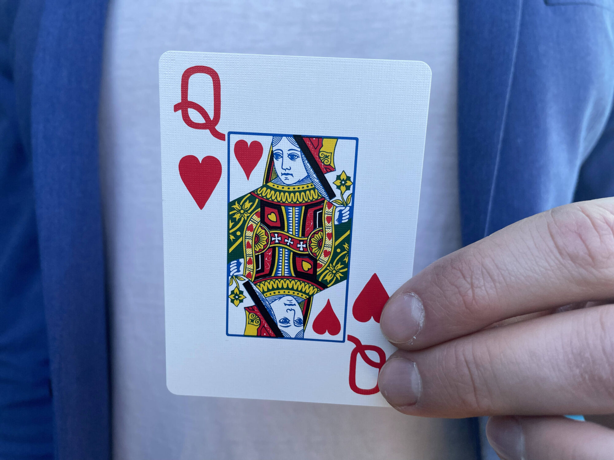Mand holder et spillekort med hjerterdame på