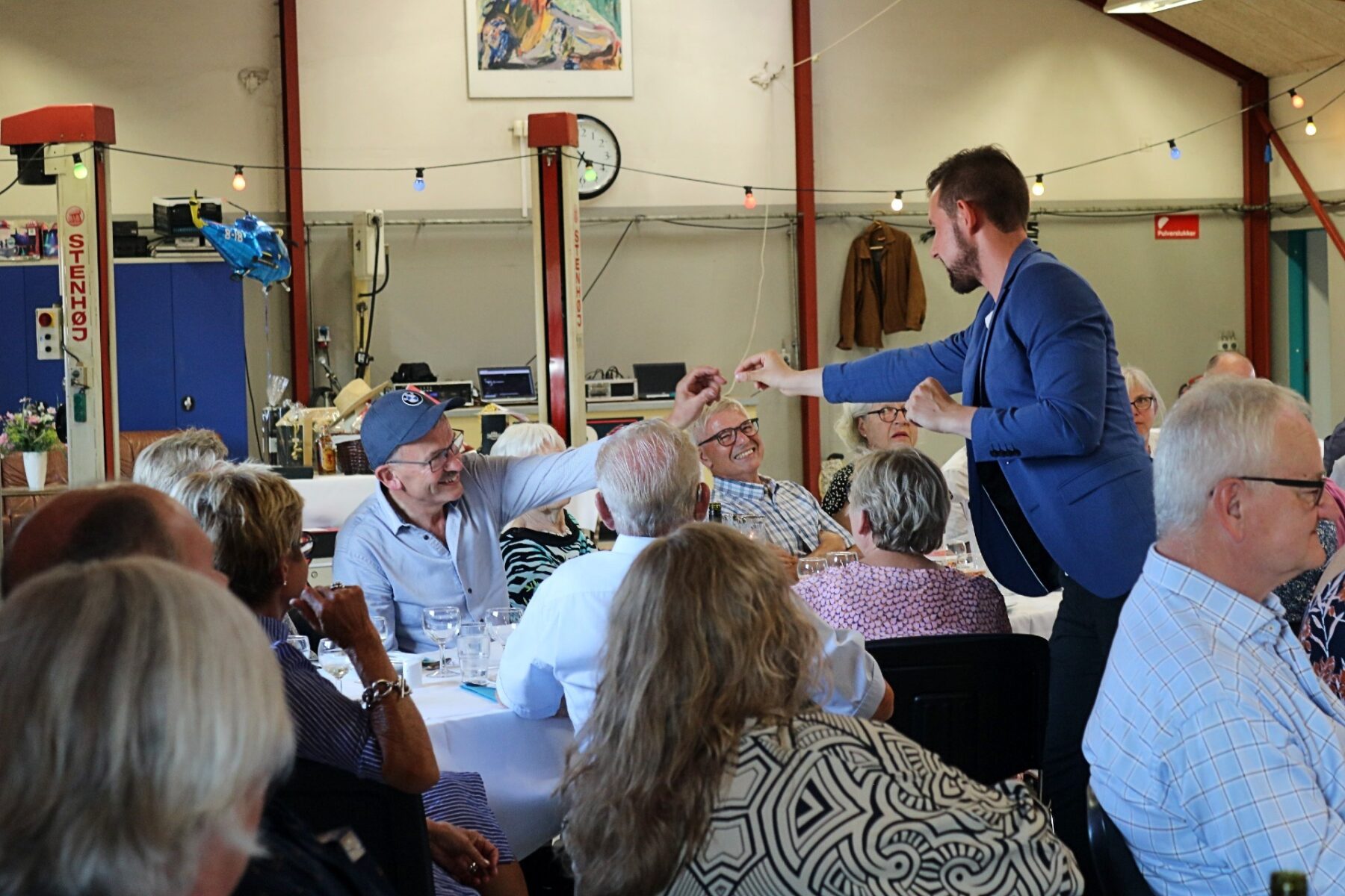 Nicolaj rækker en rekvisit til et medlem af publikummet