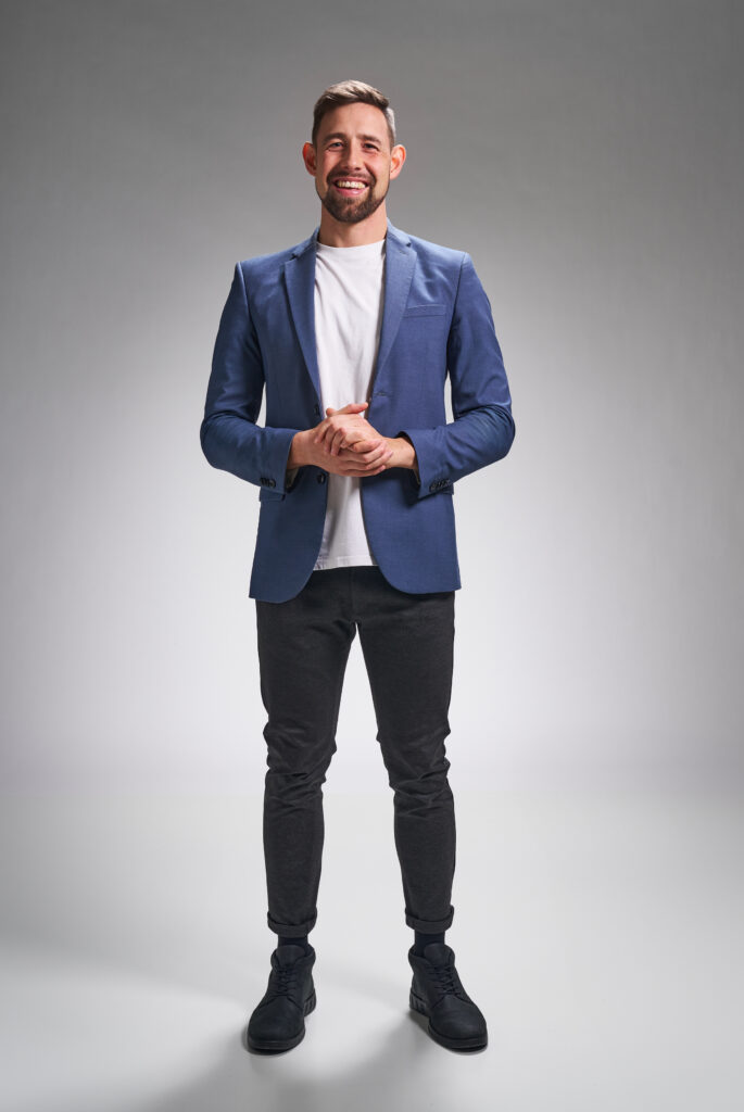 Nicolaj Mogensen, smilende tryllekunstner i blå jakke, klar til at underholde til festen.