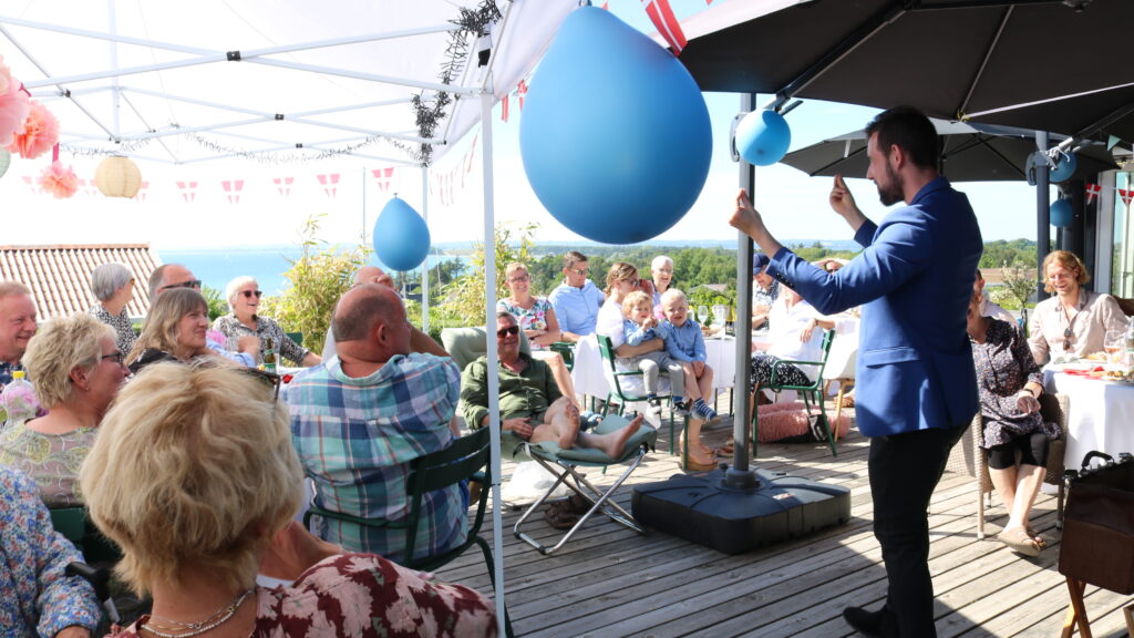 Magisk entertainer Nicolaj Mogensen underholder til sommerfest med publikum.