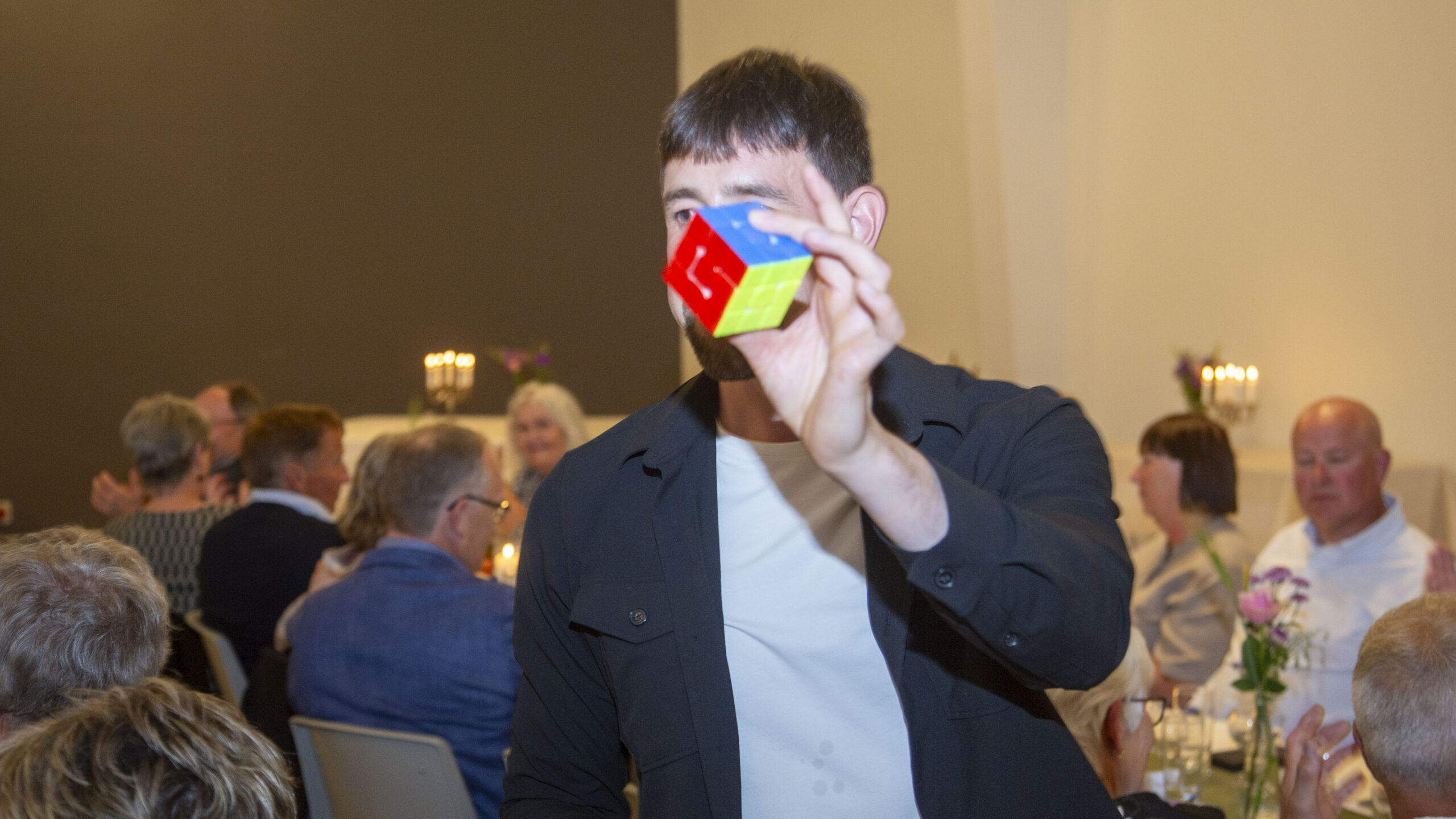 Tryllekunstner Nicolaj Mogensen underholder med magi og en rubiksterning til et guldbryllup.