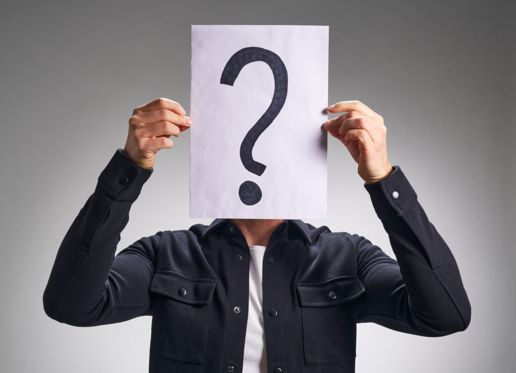 Mand med spørgsmålstegn ark papir foran ansigtet